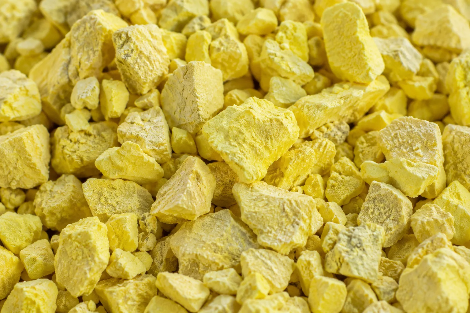 Close view of yellow sulfur particles with irregular matte surfaces